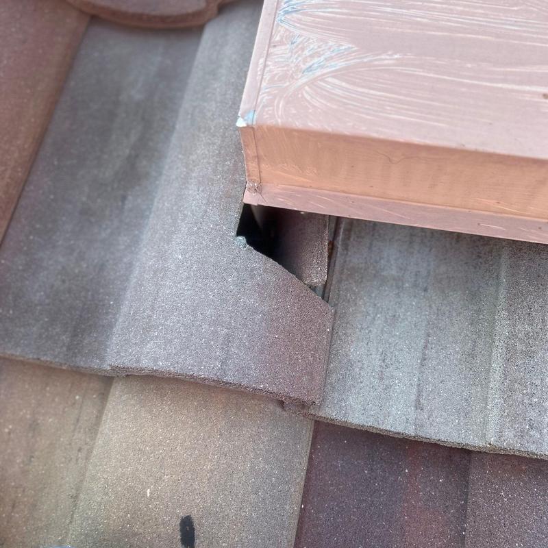 Concrete tile roof with repaired cracked tile near flashing Concrete tile roof with repaired cracked tile near flashing