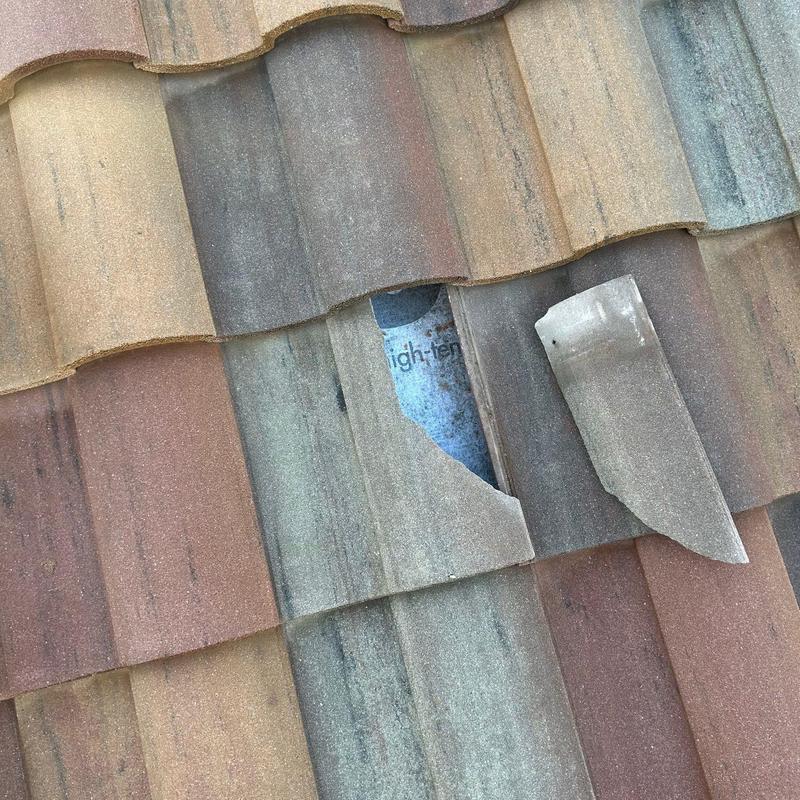Concrete tile roof with broken tile exposed underlayment Concrete tile roof with broken tile exposed underlayment