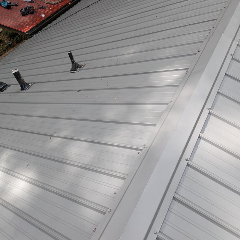 Metal roofing panels with sealed pipe penetrations Metal roofing panels with sealed pipe penetrations