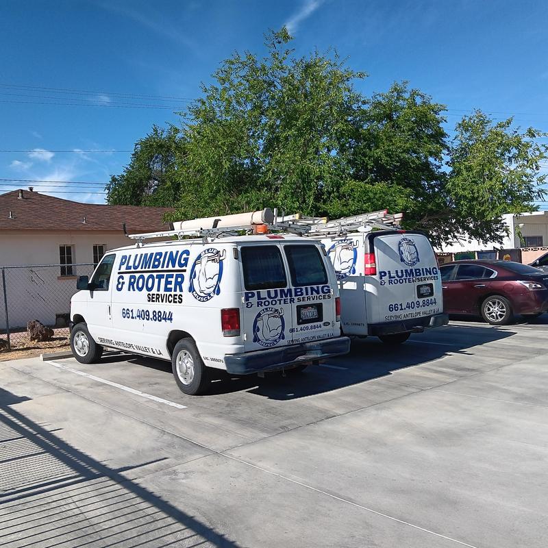 Plumbing service vans parked outside building in Lancaster