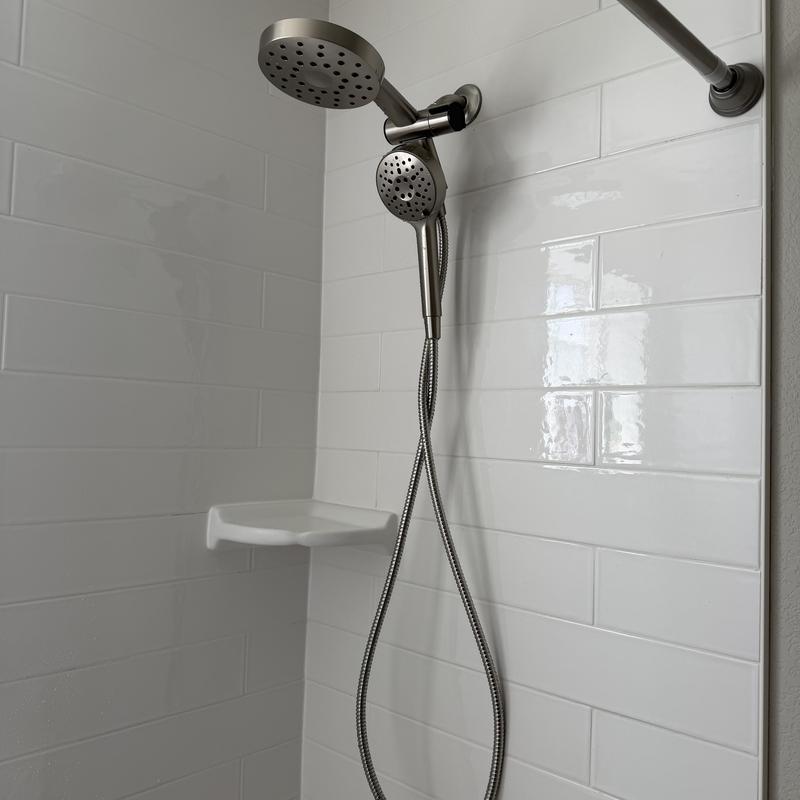 Dual shower head with hose and white tile wall Dual shower head with hose and white tile wall