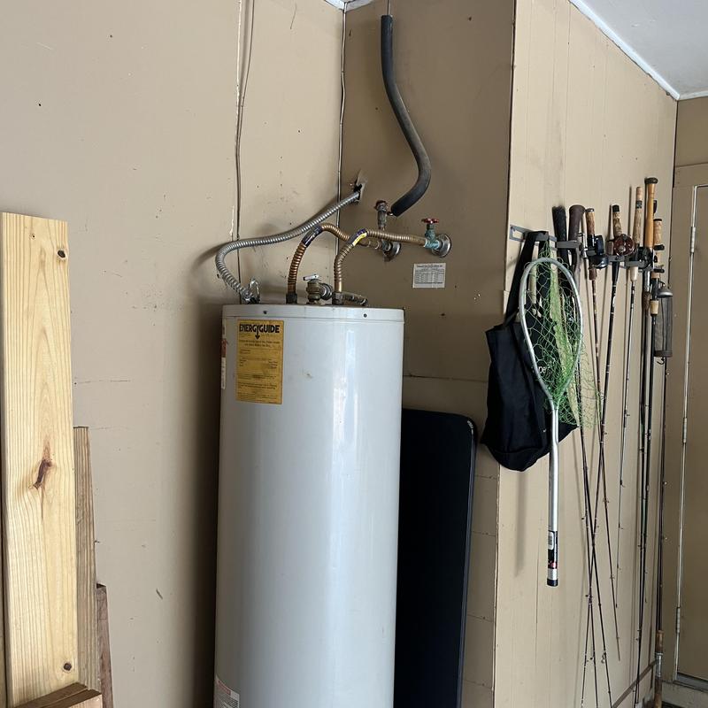 Water heater unit with piping and fishing gear nearby Water heater unit with piping and fishing gear nearby