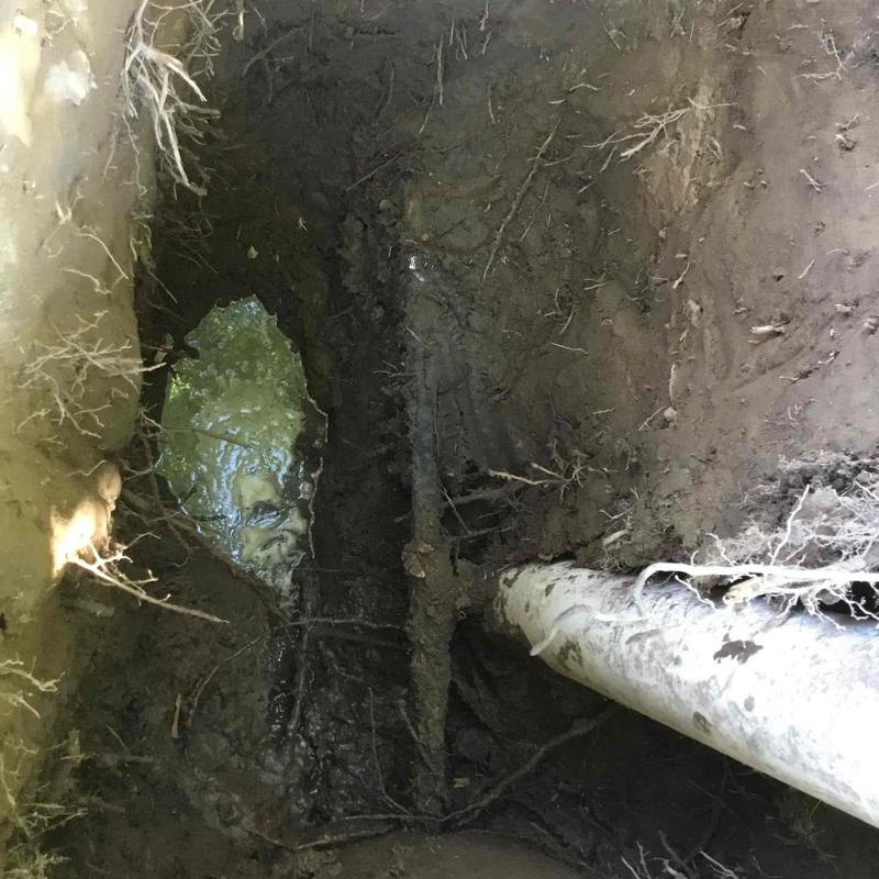 Water main excavation showing leak near meter pipe Water main excavation showing leak near meter pipe