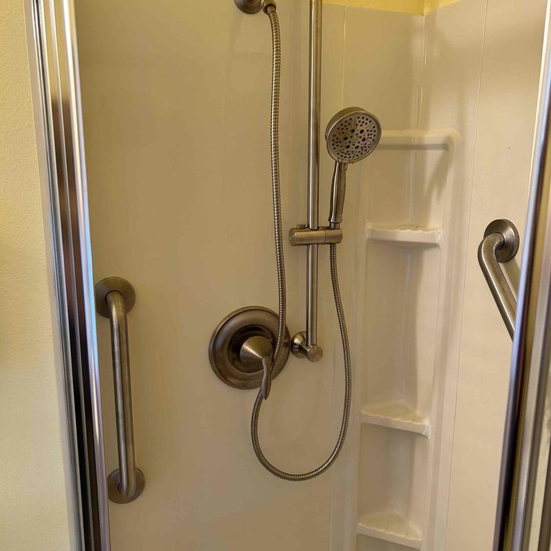 Slide bar and grab bars installed in corner shower