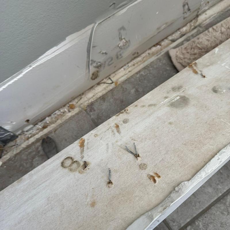 Baseboard trim with mounting nail holes and scuffs