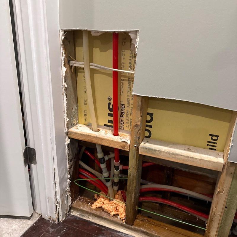 PEX plumbing pipes behind drywall with water damage