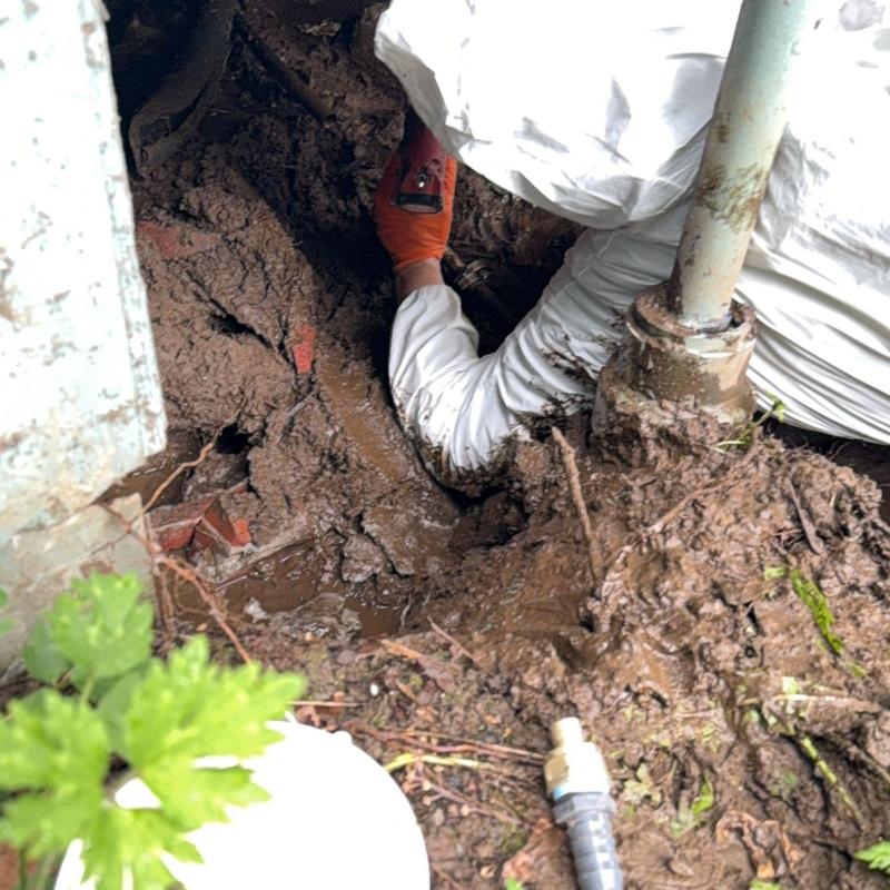 Main water line with repair in muddy soil