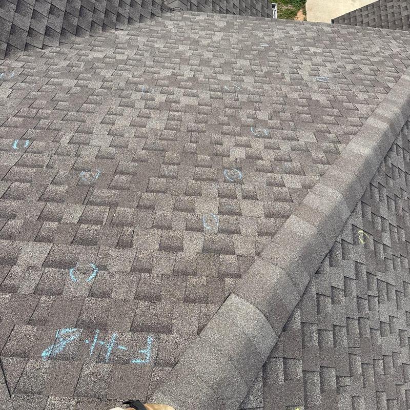Asphalt shingles with hail damage markings on roof