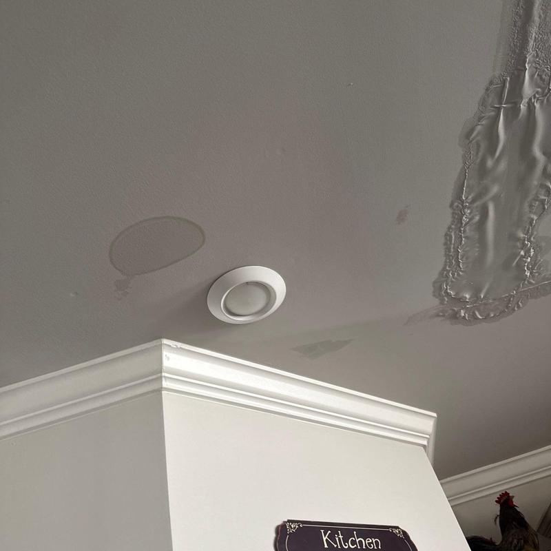 Ceiling with water damage and repaired drywall patch
