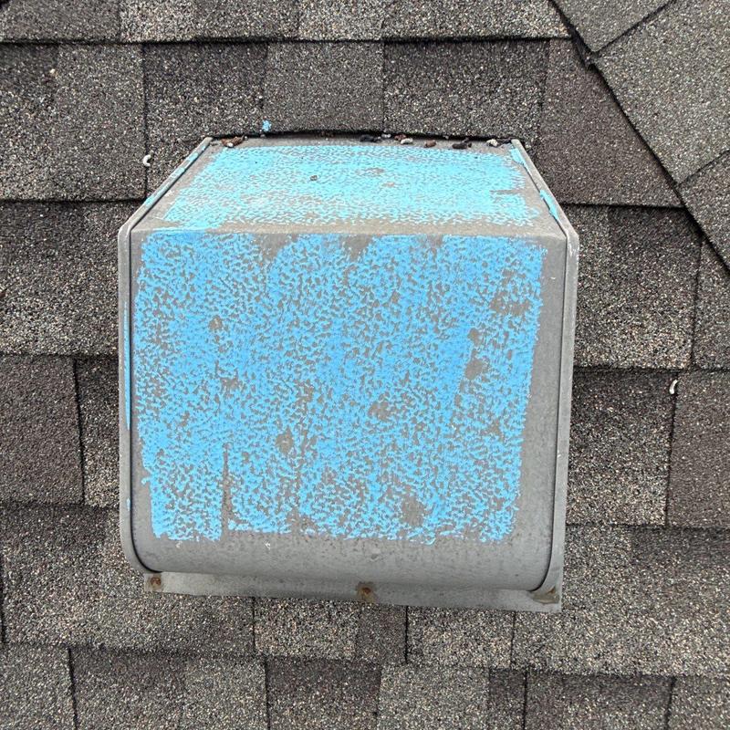Roof vent with worn blue paint on shingles