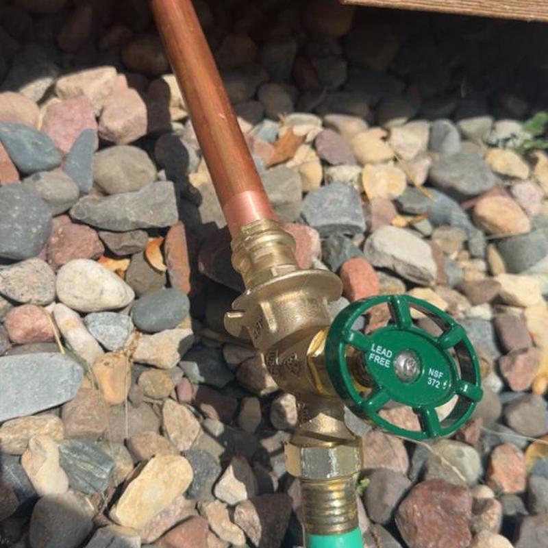 Outside spigot with green valve and copper pipe fitting