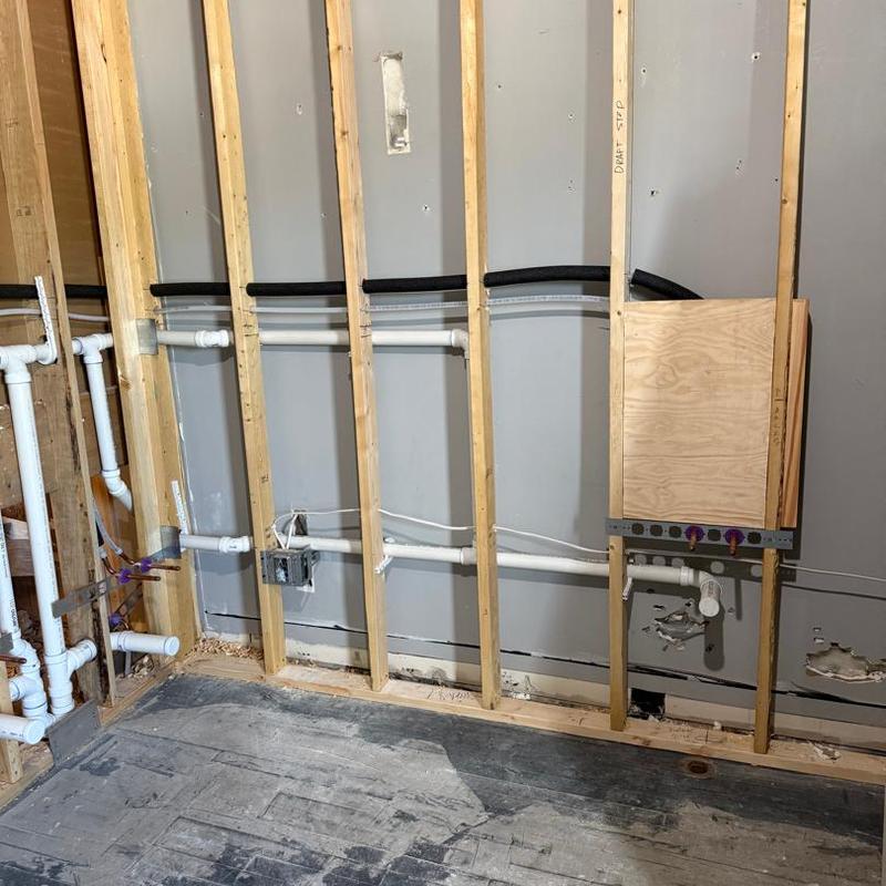 Plumbing rough-in with wall framing and piping