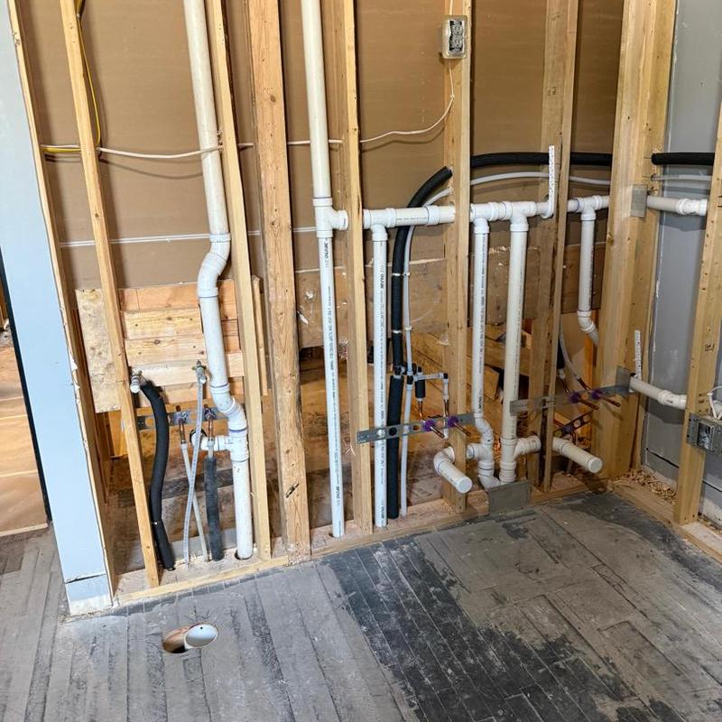 PVC rough-in plumbing installation in wall studs
