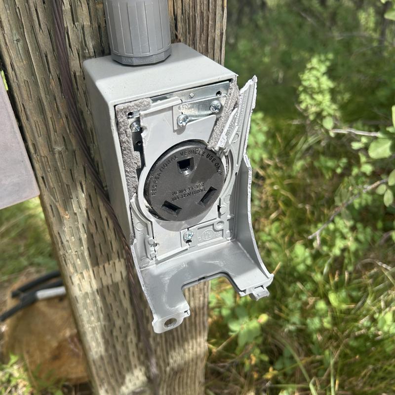 Outdoor electrical outlet box with broken cover panel Outdoor electrical outlet box with broken cover panel