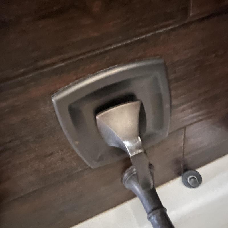 Bathroom tub faucet handle on dark tile wall Bathroom tub faucet handle on dark tile wall