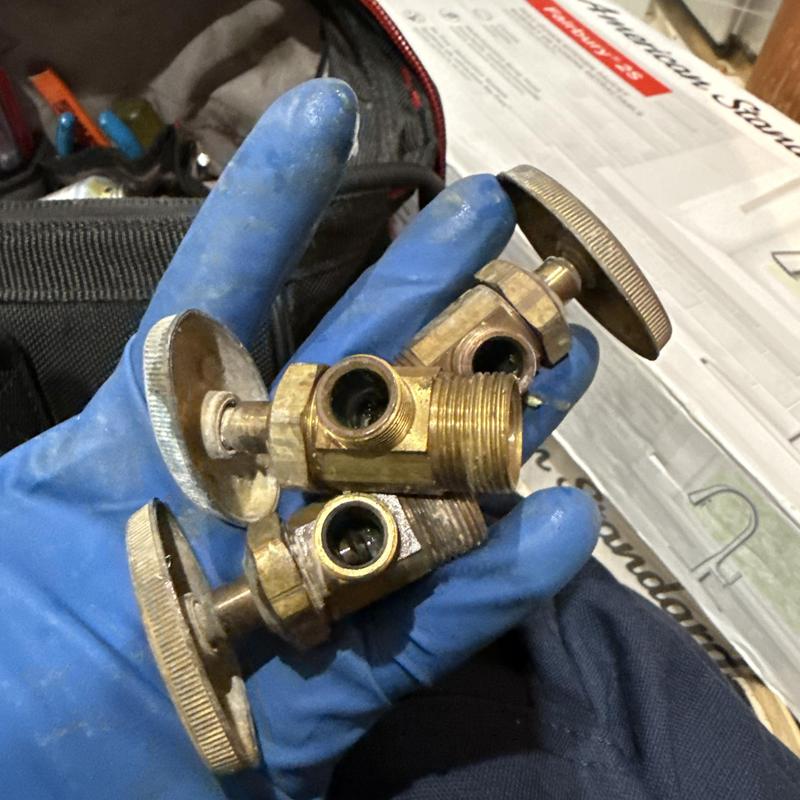 Quarter-turn angle stop valves held in gloved hand