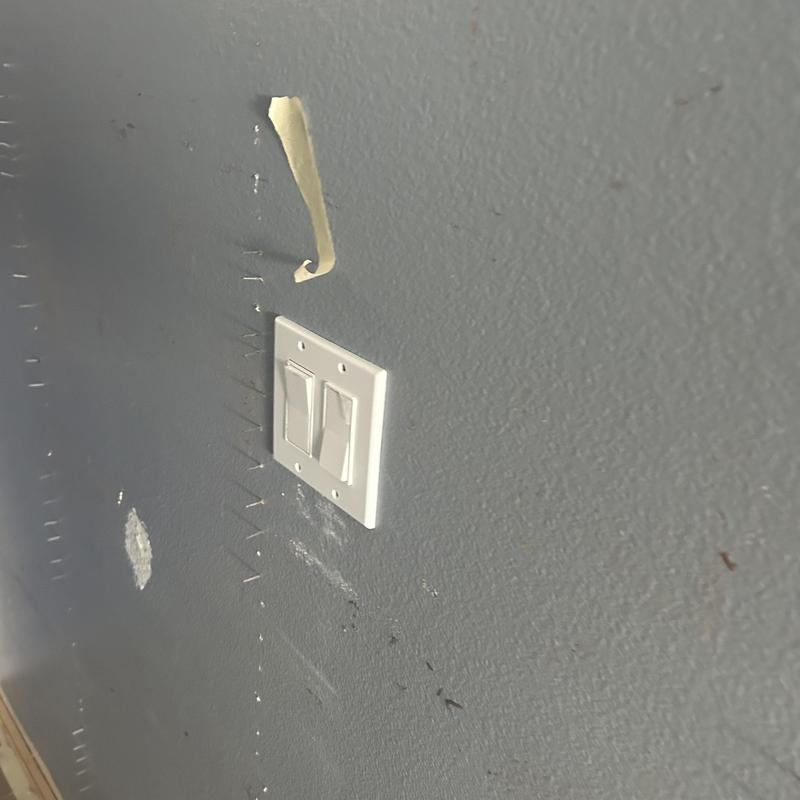 Double light switch with new cover plate on gray wall Double light switch with new cover plate on gray wall