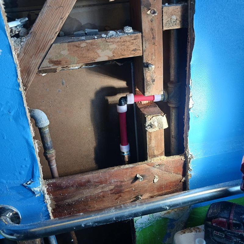 Burst hot water pipe with new PEX fittings in wall cavity