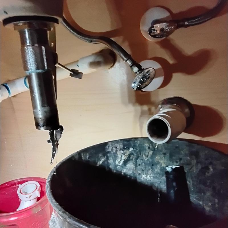 AC drain line and lavatory sink plumbing connections under sink