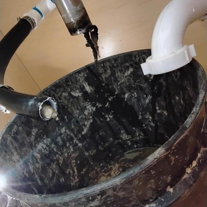 AC drain line clogged with debris above trash can