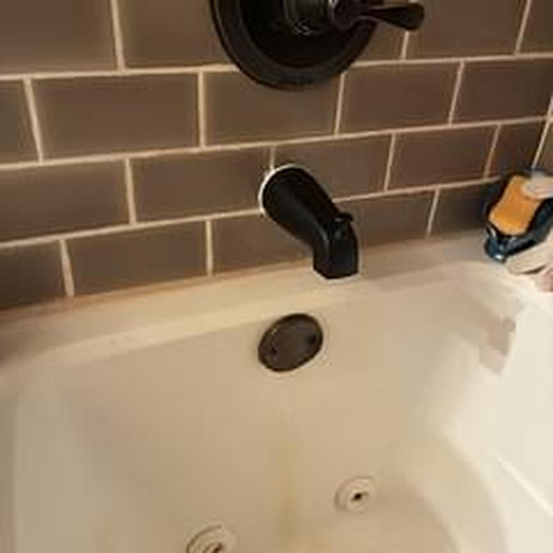 Tub spout and faucet with brown tile backsplash Tub spout and faucet with brown tile backsplash