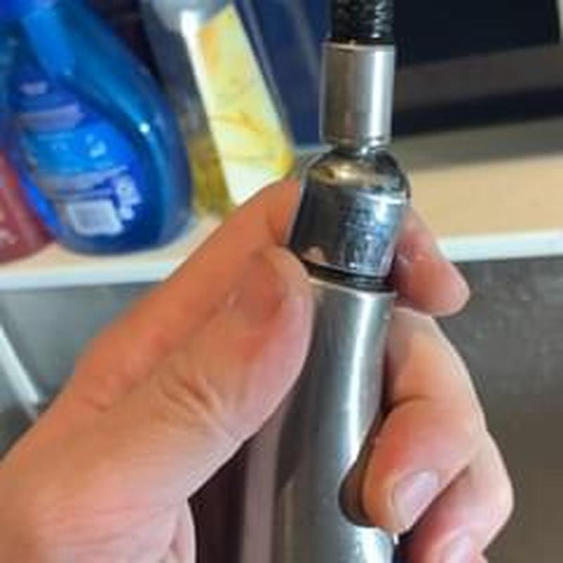 Faucet sprayer head held for leak inspection under sink Faucet sprayer head held for leak inspection under sink
