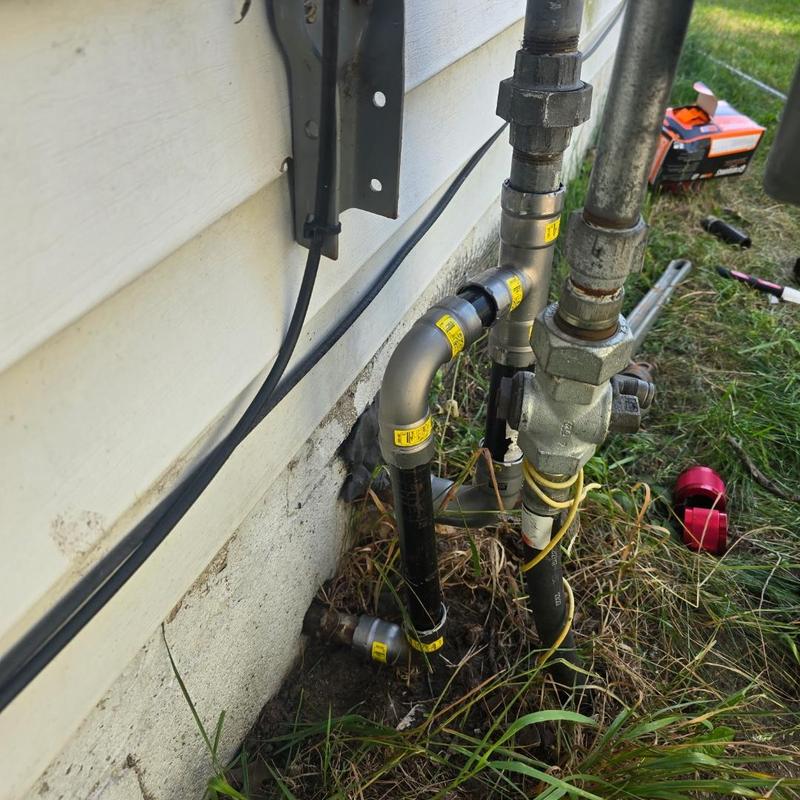 Gas valve piping outside home with leak repair tools