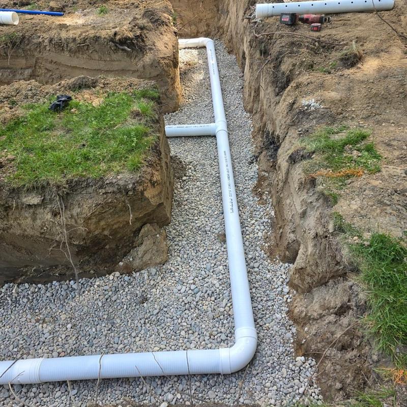 Septic drainage pipe installation in gravel trench