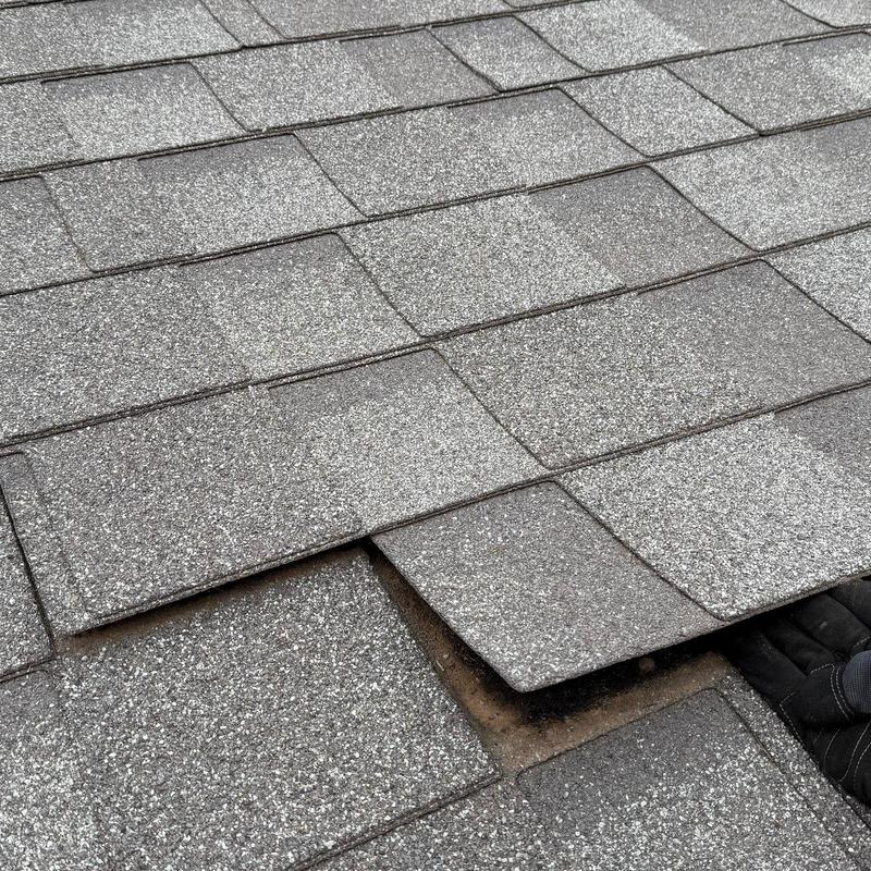 Asphalt roof shingles lifted for inspection or repair