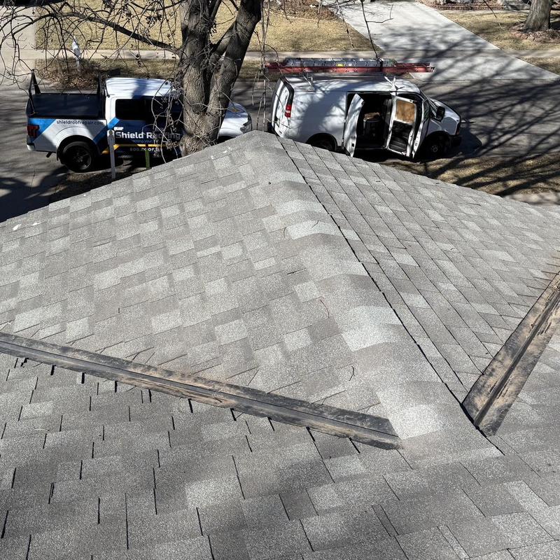 Asphalt shingle roof with repaired ridge and valley flashing
