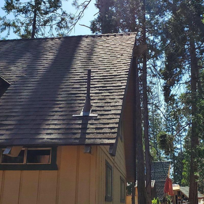 Asphalt shingle roof on storm-damaged cabin in Mi wok