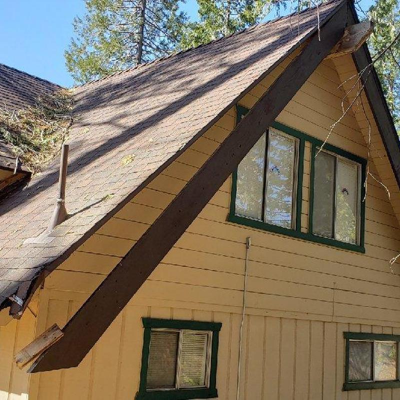Asphalt shingle roof on cabin with angled wooden beams