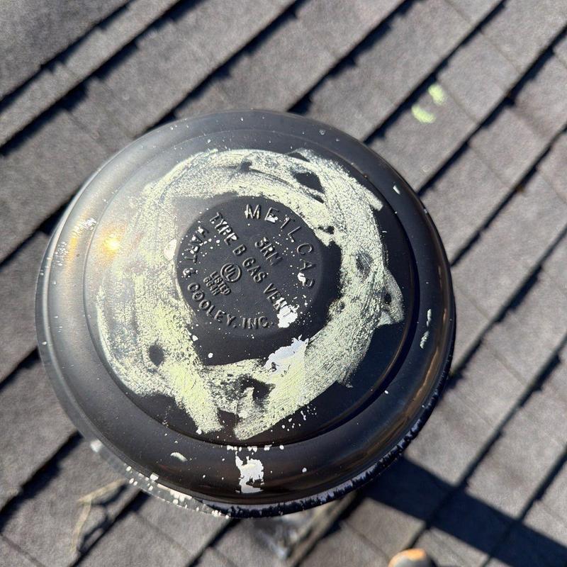Roof vent cap with hail damage on shingles