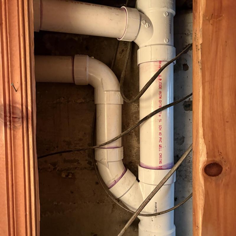 PVC plumbing stack and vent piping in basement wall cavity