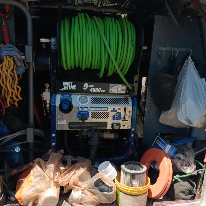 Hydrojetting machine with hose in plumbing van