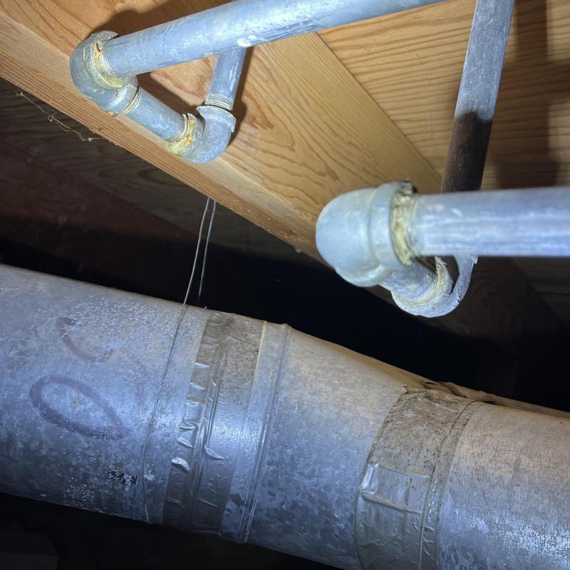 Galvanized plumbing pipes with corroded joints under floor Galvanized plumbing pipes with corroded joints under floor