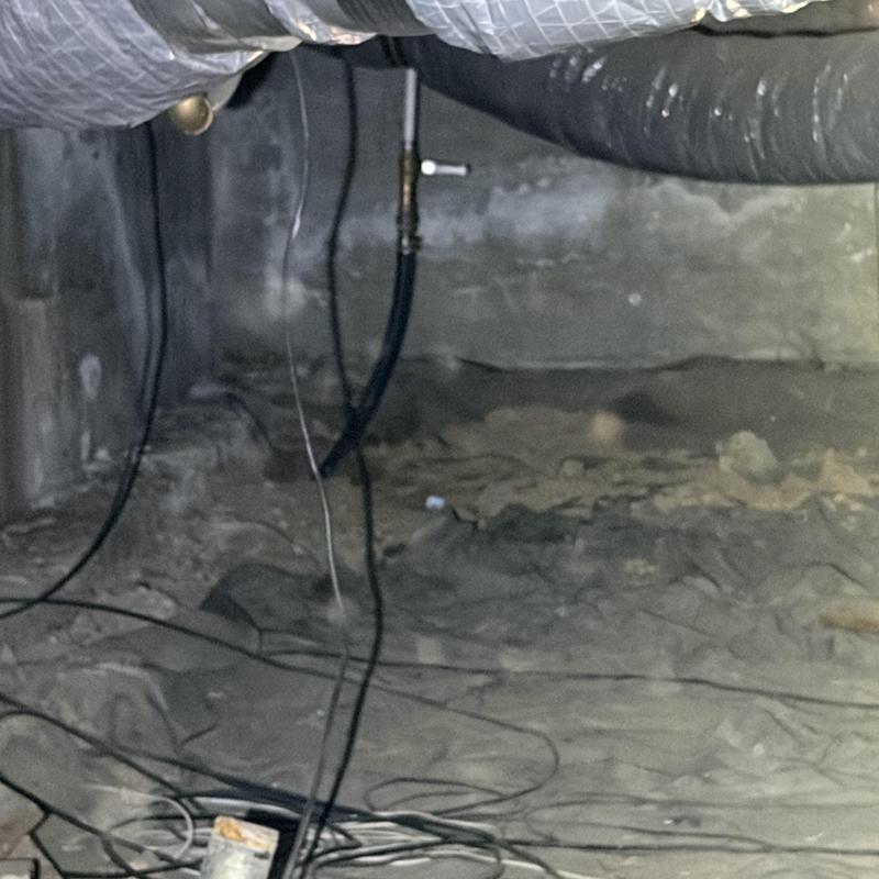Sewer main pipe in dusty crawl space with wiring Sewer main pipe in dusty crawl space with wiring