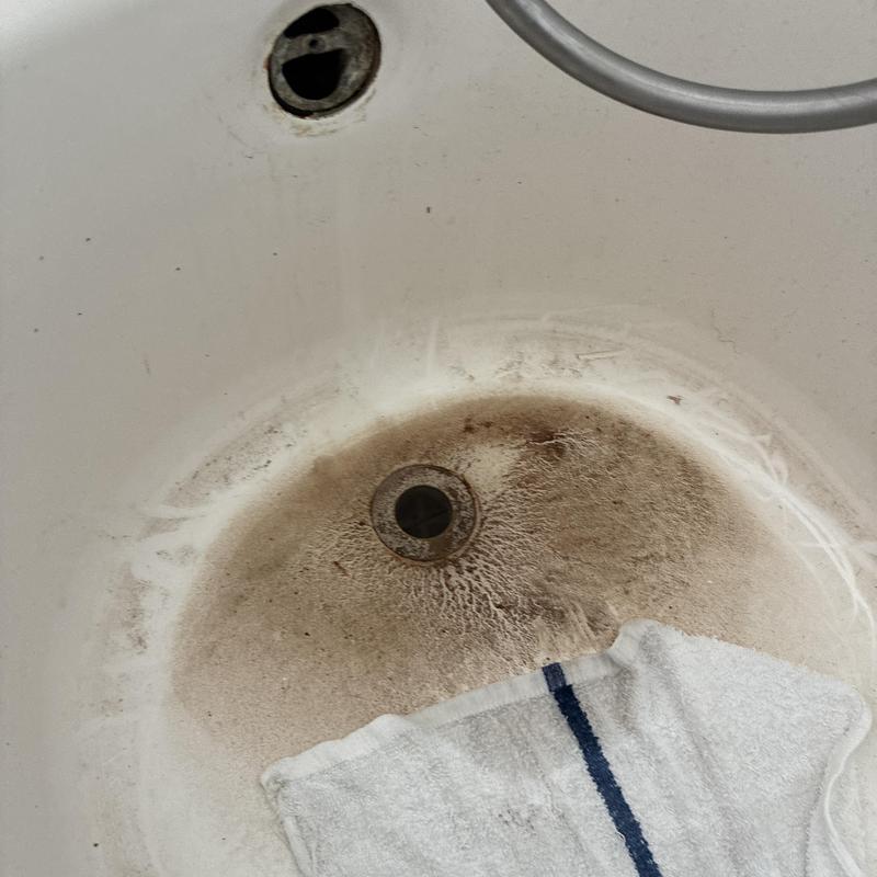 Bathtub drain clog with dirt buildup before cleaning