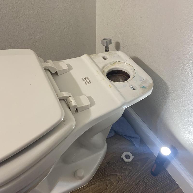 Master bathroom toilet tank with missing flush valve parts