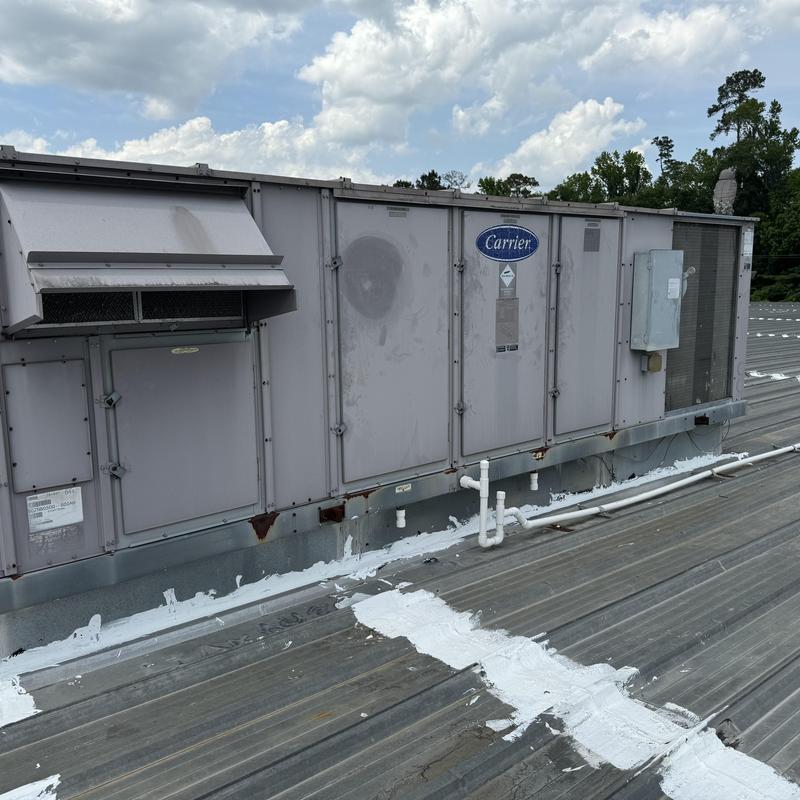 Rooftop Carrier HVAC unit with drain pipes on roof Rooftop Carrier HVAC unit with drain pipes on roof