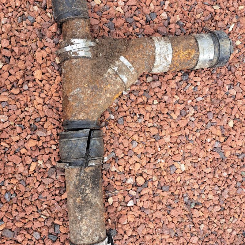 Clay lateral pipe with cracked coupling on gravel ground