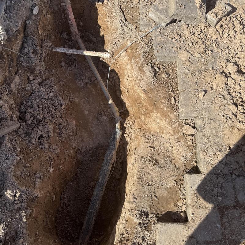 Watermain pipe with pinhole leak in trench excavation Watermain pipe with pinhole leak in trench excavation