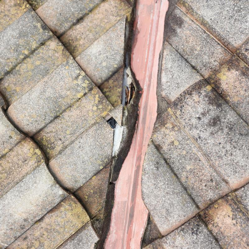 Tile roof valley with visible crack and damage Tile roof valley with visible crack and damage