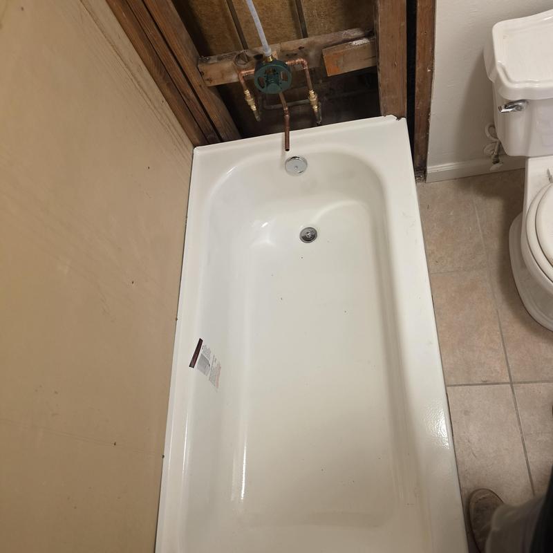 Bathtub with new valve and exposed plumbing installation