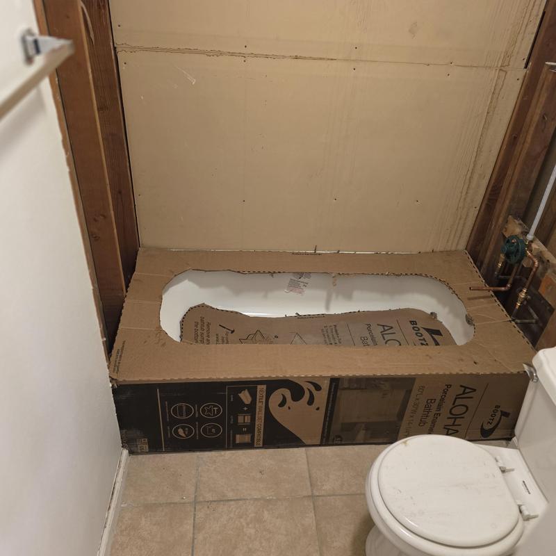 Bathtub installation with protective cardboard in bathroom
