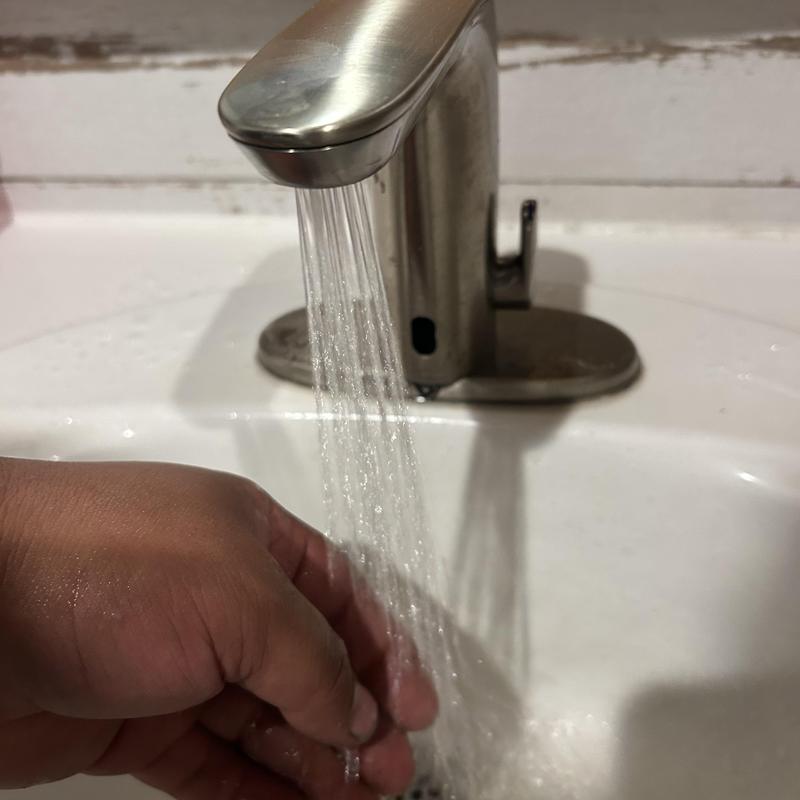 Commercial faucet water flow testing in restroom sink Commercial faucet water flow testing in restroom sink
