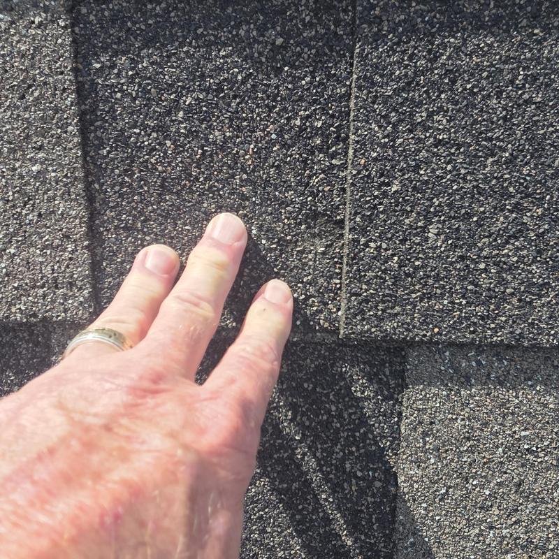 Asphalt shingle roof with hail damage close-up