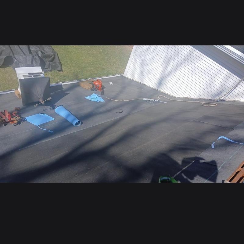 Flat roof membrane installation with tools nearby Flat roof membrane installation with tools nearby