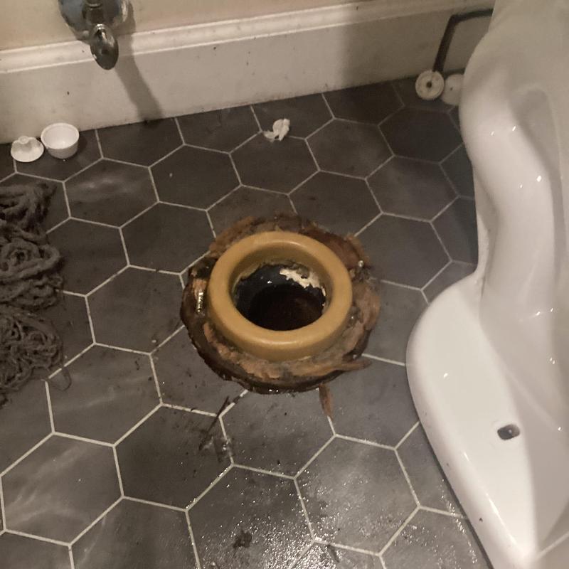 Toilet flange and drain on hex tile bathroom floor Toilet flange and drain on hex tile bathroom floor