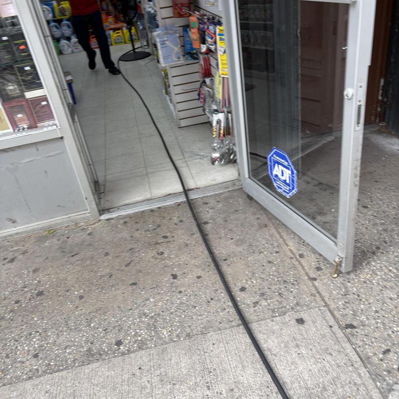 Sanitary drain cleaning hose entering store doorway Sanitary drain cleaning hose entering store doorway